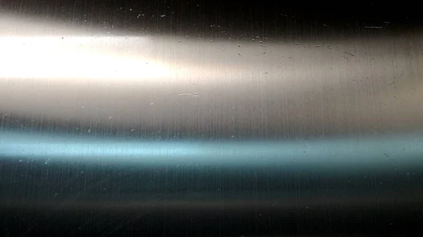 The shiny stainless steel surface is caused by light shining down on the metal surface.