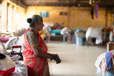 Geleneksel kıyafet katlayan kadın, Dhobi Ghat, Kochi, Hindistan 'da hava çamaşırları, 20 Mart 202