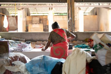 Geleneksel giysili kadın elinde antika bir kömür ütüsüyle, Dhobi Ghat, Kochi, Hindistan 'da 29 Mart 202' de hava çamaşırhanesini açıyor.