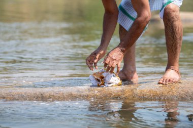 Hint kıdemli adam Tungabhadra nehrinde çamaşır yıkıyor, Hampi, Hindistan 'ın geleneksel yaşam tarzı ve kültürü, çamaşır günü.