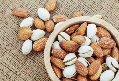 Badem ahşap kase bir çuval üzerinde.