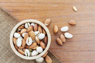 Bir kase çuval ve ahşap zemin badem.