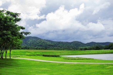 Çimlere ve dağlar parkta gölet.