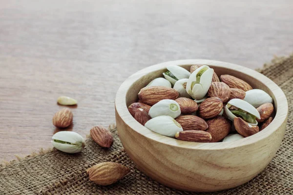 Badem ahşap zemin üzerinde bir kasede.