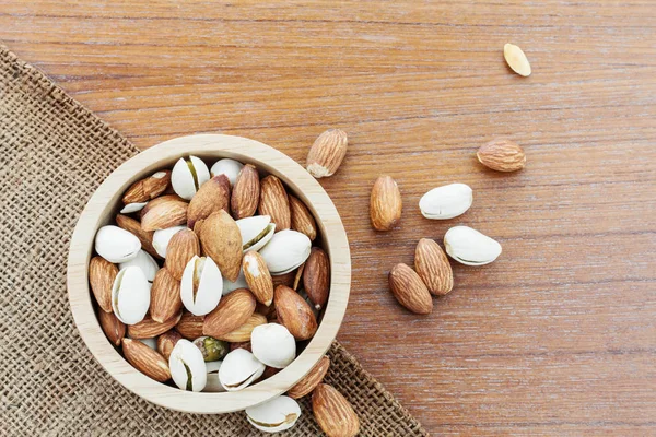 Bir kase çuval ve ahşap zemin badem.