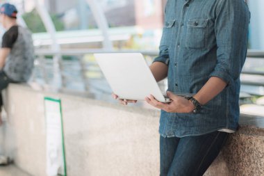 Şehirde dizüstü bilgisayar kullanan biri..