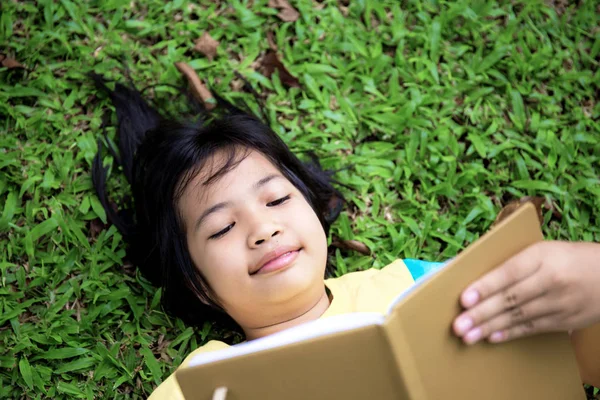 Asijská Dívka Čte Knihu Trávníku Parku — Stock fotografie