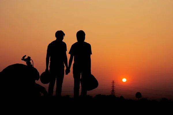 Paar motorrijders bij zonsondergang. — Stockfoto