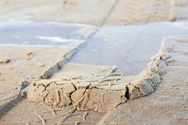 Wheel marks on sand.