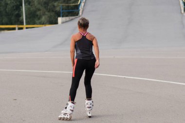 Stadyumda son sınıf öğrencisi, patenle kayan bir kadın dikiz aynası. 