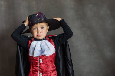 Gri arka planda cadılar bayramı vampir kostümü giyen küçük çocuk. 