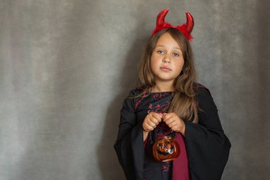 Cadılar Bayramı cadı kostümlü şeker kız gri arka planda 