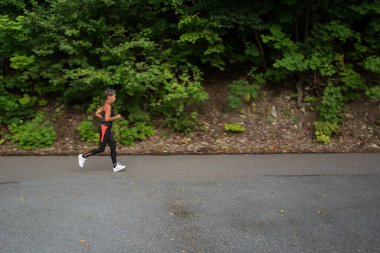 Parkta koşan aktif son sınıf öğrencisi kadın.