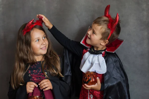 Chico y chica en halloween maldito traje en gris fondo —  Fotos de Stock