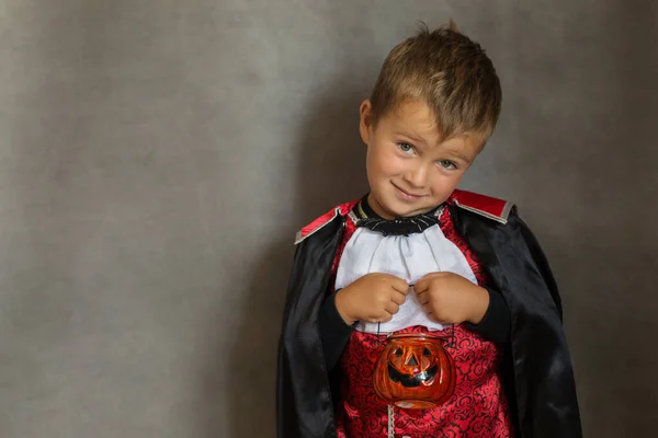 Candy chlapec v halloween upíří kostým na šedém pozadí — Stock fotografie