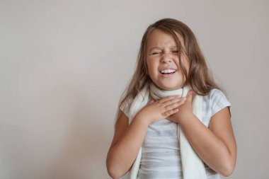 Küçük kızın boğazı ağrıyor ve beyaz atkısı var.. 