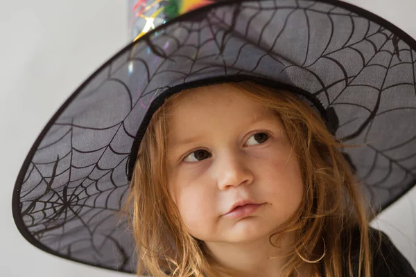 Batole dívka v halloween čarodějnice kostým na šedém pozadí — Stock fotografie