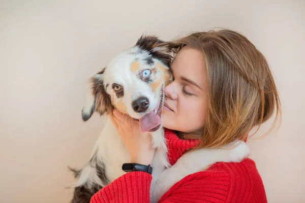 European woman in red jacket with Australian shepherd face to face — Stock Photo, Image