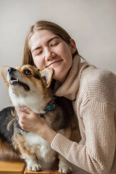 Mujer europea feliz en chaqueta sosteniendo corgi pembroke perro — Foto de Stock