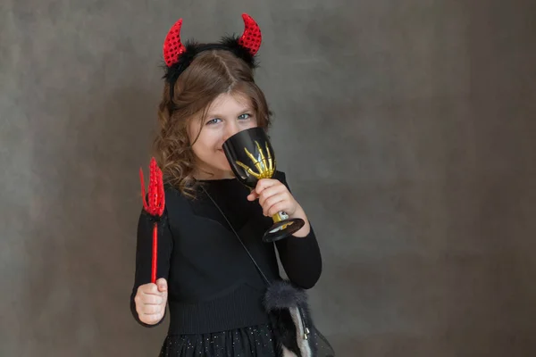 Evropská dívka v halloween zatracený kostým držení trojité a pití — Stock fotografie