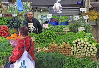 Tel Aviv, İsrail - 30 Kasım 2017: Yeşiller Carmel Pazarı, Tel Aviv, İsrail, adam satıyor
