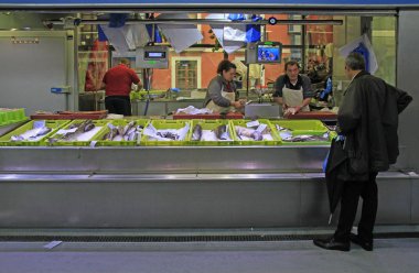 Bilbao, Spain - May 27, 2018: woman sells fish and sea food at the market in Bilbao, Spain clipart