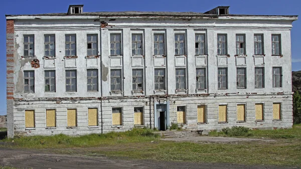 Övergiven byggnad av skolar i byn Teriberka Royaltyfria Stockbilder