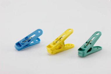Plastik klip, yeşil, sarı, mavi beyaz arka plana yerleştirilmiş..