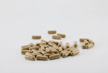 Beyaz arkaplana yerleştirilmiş bitkisel kapsüller.