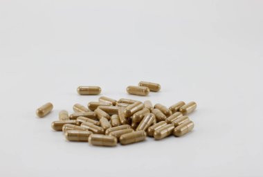 Beyaz arkaplana yerleştirilmiş bitkisel kapsüller.