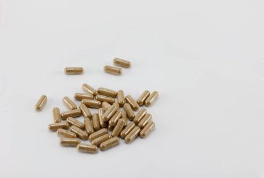 Beyaz arkaplana yerleştirilmiş bitkisel kapsüller.