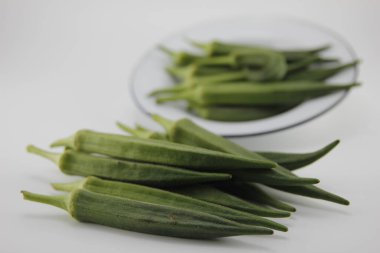 Bamyayı bir kaseye koy, beyaz arka plan üzerine..