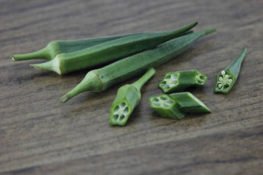 Tahta kiremitlerin üzerinde yatan bamya.