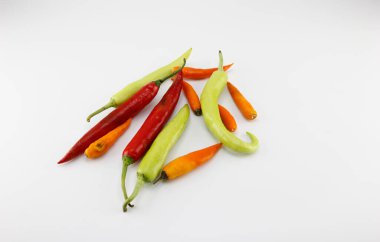 Beyaz arka plana yerleştirilmiş sarı, yeşil, kırmızı biberler.