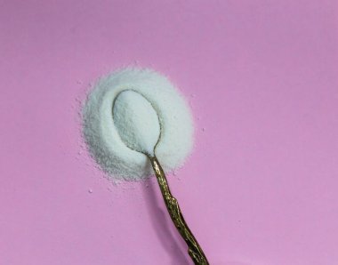 Kolajen tozu bir kaşık üzerinde Pembe zemin.