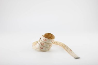 Beyaz arkaplandaki mezura ölçülüyor.