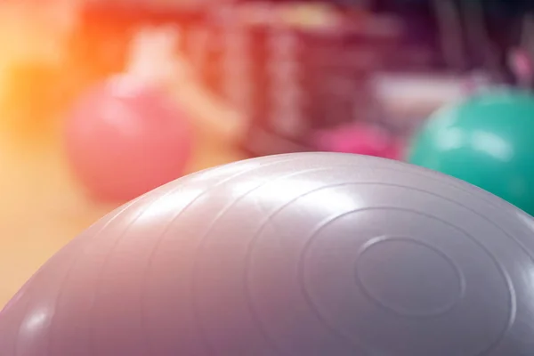 exercising with personal trainer on large stability ball in studio fitness back physiotherapy