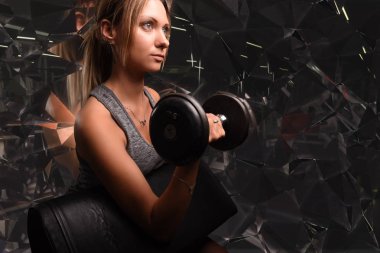 Genç güzel kadın Biceps curl Ez curl bar bir spor salonu ile yapıyor. Fitness merkezinde egzersiz yapıyor atletik kız