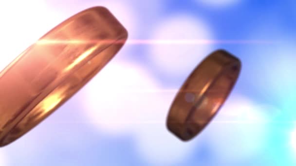 2 anillos de boda dorados que se fusionan con un hermoso fondo bokeh azul — Vídeo de stock
