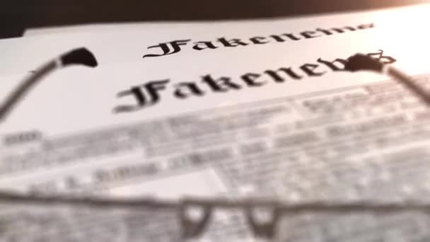 Очки с газетой с заголовком "Fakenews" на столе — стоковое видео