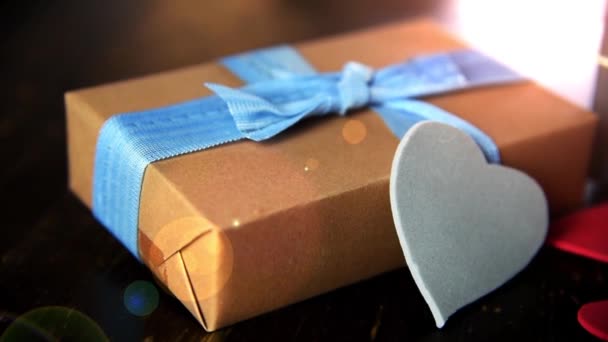 Gift boxes with paper hearts on wood table close up — Stock Video