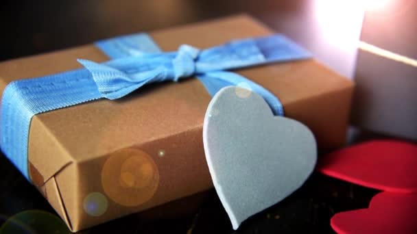 Gift boxes with paper hearts on wood table close up — Stock Video