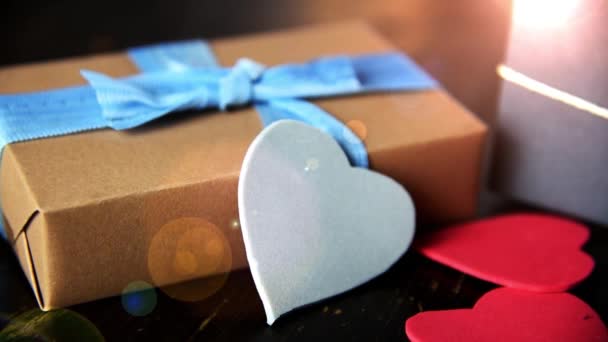 Подарочные коробки с бумажными сердцами на деревянном столе — стоковое видео