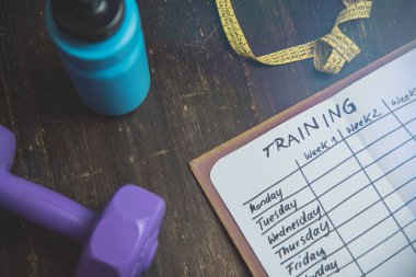 Ahşap masa Not defterinizdeki bir egzersiz planı yüksek açılı görünüş