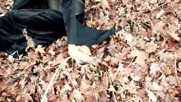 Viking woman runs hands through the autumn leaves — Stock Video