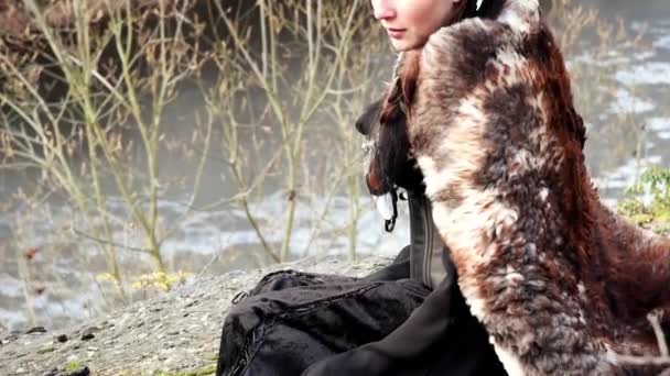 Beautyful viking woman seated on a rock in autumn nature landscape — Stock Video