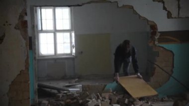 Terk edilmiş bir evde yerde kurulu depresif ve deli bir adam atar