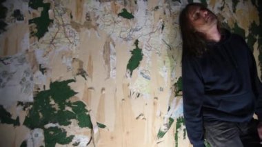 Orta yaşlı adamım ya da deli duran eski terk edilmiş bir evde köşesinde