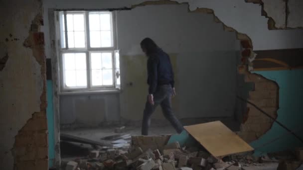 Депрессивный и злой мужчина бросает Бретта через комнату в заброшенном доме — стоковое видео