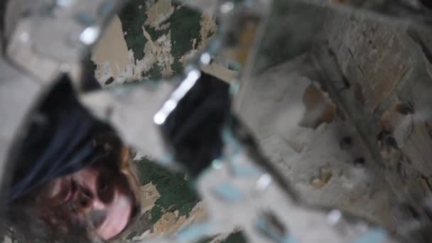 Homem deprimido e zangado olha em fragmentos de vidro quebrados — Vídeo de Stock
